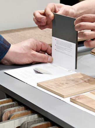 Kundenberatung im Fachhandel: Zwei Personen begutachten verschiedene Materialmuster für Bodenbeläge.