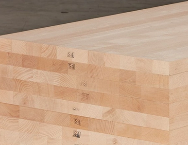 Gestapelte Massivholzplatten mit durchgehenden Lamellen, ideal für den Möbel- und Innenausbau.