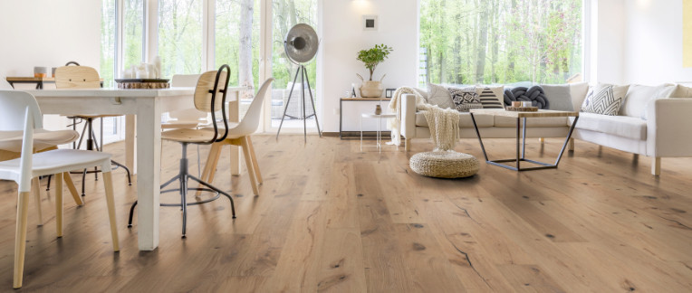 Im Wohnzimmer wurde Parkett in Langdielen-Optik verlegt. Ein Sofa und einige liebevoll platzierte Dekoelemente runden das gemütliche Ambiente ab.