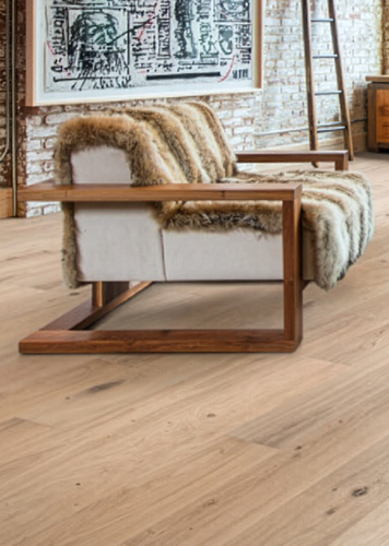 Wohnzimmer im Loftstil mit Ledersofa, Couchtisch und hellem Holzboden.
