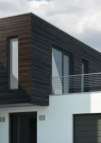 Ein modernes Haus mit weißer Fassade und Akzenten aus dunklem Holz